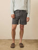 Video of a man wearing black shorts with a light blue henley against a beige background