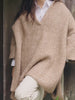 Video of a woman wearing a light brown sweater over a white poplin shirt