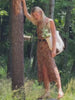 Woman wearing an orange printed dress standing outside in nature