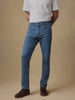 Video of a man wearing a striped t-shirt and blue jeans against a beige background