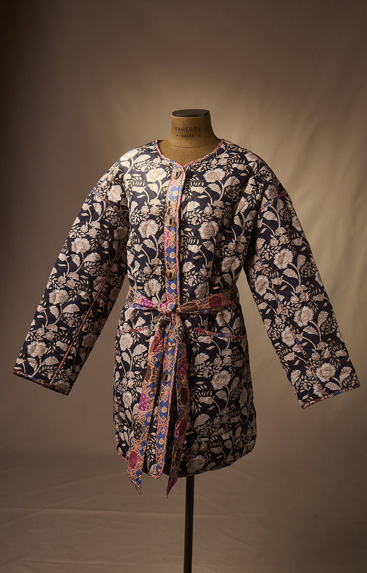 Reversible quilted jacket on a dress form infront of a canvas back drop