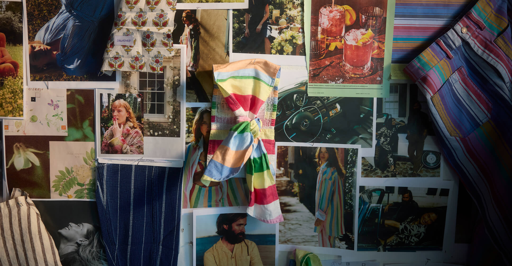 A moodboard wall covered in women's lifestyle fashion imagery and colorful fabric swatches